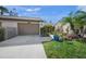 Exterior view of villa featuring a two-car garage and neatly landscaped front yard at 5958 Clubside Dr, Sarasota, FL 34243