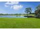 Serene view of a lake at Palm Aire, featuring lush landscaping and a reflection of clouds at 5958 Clubside Dr, Sarasota, FL 34243