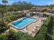 Community pool and spa with lounge chairs and lush foliage at 5958 Clubside Dr, Sarasota, FL 34243