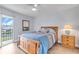 Bedroom with a wooden bed frame and access to a balcony overlooking a canal at 6507 Stone River Rd # 306, Bradenton, FL 34203