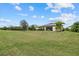 Spacious backyard with grassy area and a home with solar panels at 6519 Rosehill Farm Run, Bradenton, FL 34211