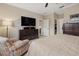 Primary bedroom with a dresser, TV, and walk-in closet at 6519 Rosehill Farm Run, Bradenton, FL 34211