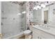 Spa-like bathroom with marble shower, toucan wallpaper and modern fixtures at 7022 Prosperity Cir # 801, Sarasota, FL 34238