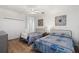 Spacious bedroom with two twin beds, light wood floors, and ceiling fan at 7022 Prosperity Cir # 801, Sarasota, FL 34238