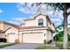 Two-story tan house with a two car garage, landscaping and a tree in front at 7022 Prosperity Cir # 801, Sarasota, FL 34238