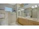 Bathroom with double vanity, glass shower, and a block window at 7419 Albert Tillinghast Dr, Sarasota, FL 34240