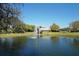 Community pond with a charming fountain and lush landscaping at 7419 Albert Tillinghast Dr, Sarasota, FL 34240