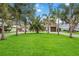 Charming home with a lush green lawn and palm trees at 8135 Longbay Blvd, Sarasota, FL 34243