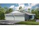 Two-car garage, light gray exterior, and landscaping at 10522 Eclipse St, Sarasota, FL 34241