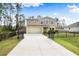 Two-story house with a tan exterior, black fence, and landscaped front yard at 1379 E Price Blvd, North Port, FL 34288