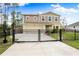 Two-story house with a tan exterior, black fence, and landscaped front yard at 1379 E Price Blvd, North Port, FL 34288
