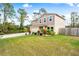Two-story house with a tan exterior, wooden fence, and landscaped yard at 1379 E Price Blvd, North Port, FL 34288