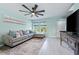 Spacious living room with gray sectional sofa, ceiling fan, and hardwood floors at 1379 E Price Blvd, North Port, FL 34288