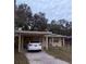 Ranch home with carport, small yard, and mature trees at 1519 30Th St, Sarasota, FL 34234