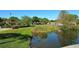 Serene pond with lush landscaping and view of community buildings at 205 Oak Hill Dr # 7, Sarasota, FL 34232
