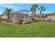 Landscaped backyard with screened patio and lush lawn at 230 Vestavia Dr, Venice, FL 34292