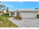 Single-story home with gray tile roof, white garage door, and landscaped front at 230 Vestavia Dr, Venice, FL 34292