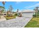 Single-story home with gray tile roof, white garage door, and stone driveway at 230 Vestavia Dr, Venice, FL 34292