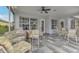 Relaxing screened porch with tiled floor, seating area, and outdoor grill at 230 Vestavia Dr, Venice, FL 34292