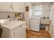 Practical laundry room with washer, dryer, and utility sink at 2325 Riverbluff Pkwy # V247, Sarasota, FL 34231
