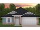 New home exterior with gray and teal siding, two-car garage, and landscaping at 2664 Averland Loop, North Port, FL 34287