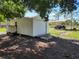 White storage shed with roll-up door and adjacent tractor at 33931 Serene Dr, Punta Gorda, FL 33982