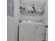 Bright laundry room with washer, dryer, and shelving for storage at 4122 Central Sarasota Pkwy # 1914, Sarasota, FL 34238