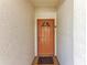 Orange door with a small window and doormat at 4366 Madeira Ct # 3356, Sarasota, FL 34233