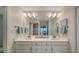 Double vanity bathroom with quartz countertops, modern lighting, and plenty of storage at 4600 Gulf Of Mexico Dr # 206, Longboat Key, FL 34228