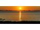 Orange sunset over the water with city skyline in the distance at 4600 Gulf Of Mexico Dr # 206, Longboat Key, FL 34228