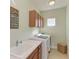 Laundry room with washer, dryer, cabinets, and utility sink at 4716 Foxtail Dr, Parrish, FL 34219