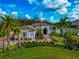 One-story house with lush landscaping and palm trees at 4986 Antiquity Way, Sarasota, FL 34240
