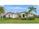 Single-story home with tile roof, landscaping, and palm trees at 4986 Antiquity Way, Sarasota, FL 34240