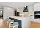 Modern kitchen with white cabinets, a large island, and hardwood floors at 4986 Antiquity Way, Sarasota, FL 34240