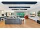 Spacious living room featuring hardwood floors, a large sectional sofa, and a beautiful view at 4986 Antiquity Way, Sarasota, FL 34240