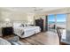 Spacious bedroom with king-size bed, ocean view, and hardwood floors at 5830 Midnight Pass Rd # 502, Sarasota, FL 34242
