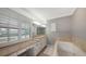 Bathroom with soaking tub, double vanity, and window shutters at 605 Wild Turkey Ln, Sarasota, FL 34236