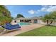 Peaceful pool area with lounge chairs, lush landscaping, and green lawn at 605 Wild Turkey Ln, Sarasota, FL 34236