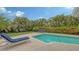 Tranquil pool and patio area with lounge chairs and lush landscaping at 605 Wild Turkey Ln, Sarasota, FL 34236