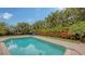 Inviting pool area with lounge chairs, lush landscaping, and brick pavers at 605 Wild Turkey Ln, Sarasota, FL 34236