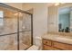 Bathroom featuring a tiled walk-in shower, granite countertop, and wood cabinets at 6630 Horned Owl Pl, Sarasota, FL 34241