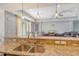 Bright kitchen with granite countertops and stainless steel sink overlooking the Gathering room at 6630 Horned Owl Pl, Sarasota, FL 34241