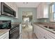 Kitchen with black appliances and view into dining area at 829 Audubon Dr # 829, Bradenton, FL 34209