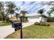 Landscaped home with a white exterior, two-car garage, and a mailbox at 8303 Deerbrook Cir, Sarasota, FL 34238