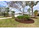 Landscaped front yard with mature trees and lush greenery at 8303 Deerbrook Cir, Sarasota, FL 34238