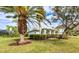 House exterior showcasing a well-maintained lawn and palm trees at 8303 Deerbrook Cir, Sarasota, FL 34238