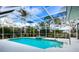 Inviting screened-in pool area with a spa and lush surrounding landscape at 8303 Deerbrook Cir, Sarasota, FL 34238