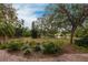 Landscaped backyard with pond view and brick walkway at 96 Tall Trees Ct, Sarasota, FL 34232