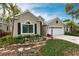 Tan house with white garage door, landscaping, and brick walkway at 96 Tall Trees Ct, Sarasota, FL 34232
