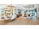 Open concept dining room with large chandelier and hardwood floors at 10160 Silent Night Ln, Sarasota, FL 34241